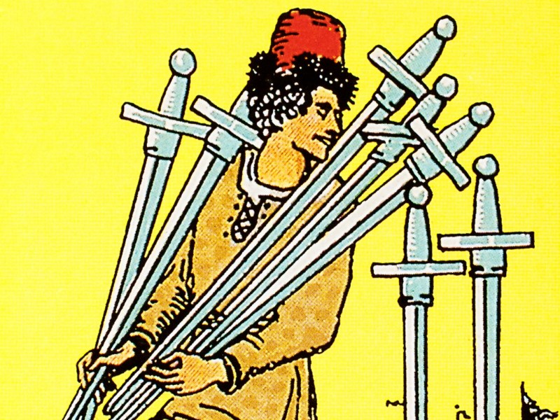A close-up illustration from the Seven of Swords tarot card featuring a figure in a red fez and orange tunic. He moves stealthily, carrying a bundle of five swords in his arms while looking back over his shoulder at two swords standing upright in the ground against a bright yellow background.